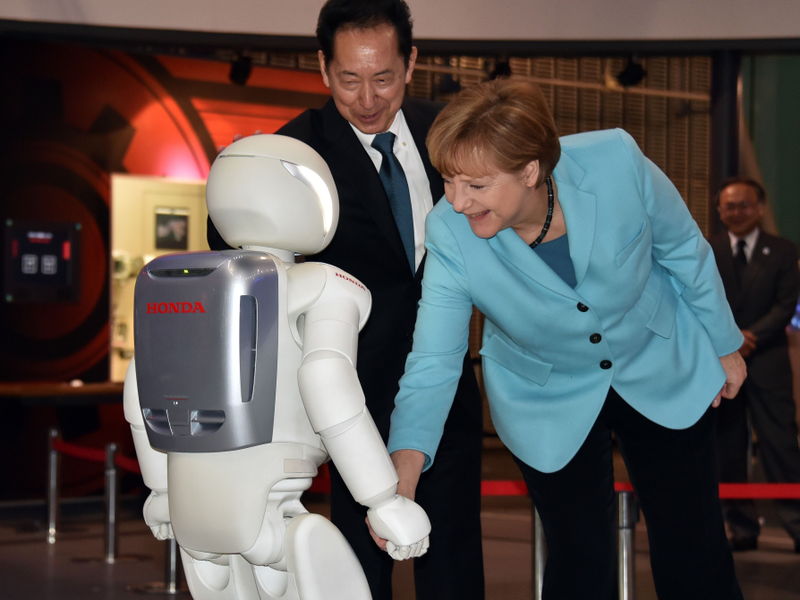 Illustration for article titled Why Is Angela Merkel Always Palling Around With Robots?